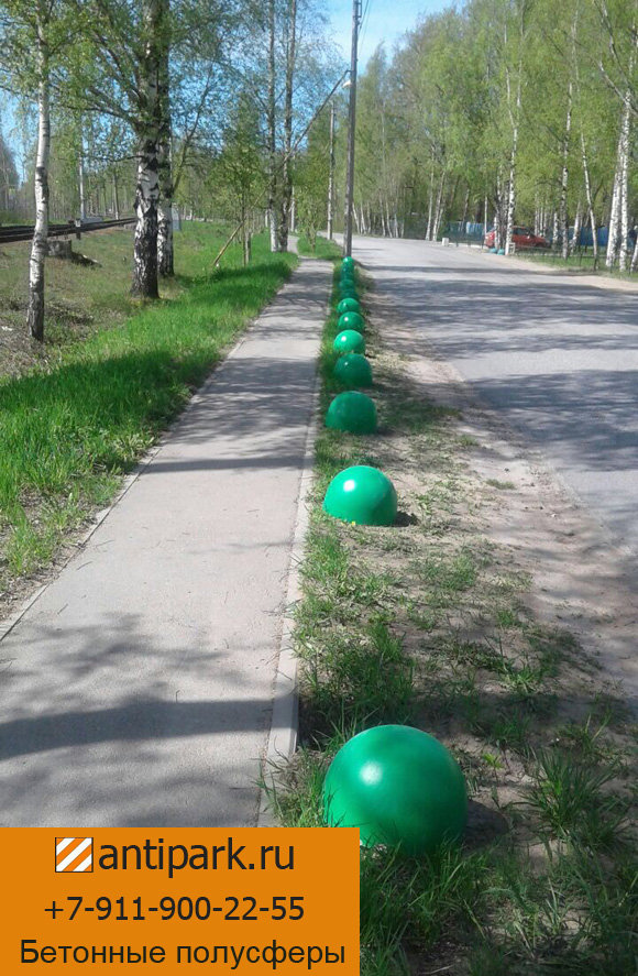 Установленные на краю дороги бетонные полусферы ПБ-410АК зеленого цвета